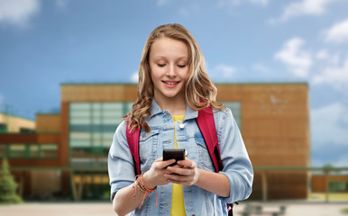 Poster - education, technology and people concept - happy smiling teenage student girl with bag and smartphone over school background