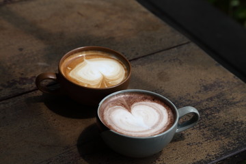 Wall Mural - Two cups of latte coffee with heart shape foam milk on rustic wooden table for dating couple concept with copy space