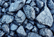 Image of coal with blue tint close up. Shiny raw/rough stones close-up. Background of shiny untreated stones.