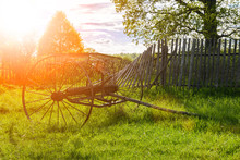 A Rusty Old Antique Hay Rake Near The Rubble Of The Fence In Summer In Russian Village
