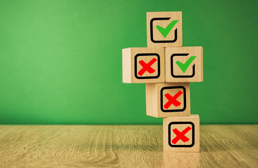 wooden cubes with the image of check marks marks on a green background.