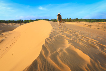 back side of woman walking on red sand dune in Mui ne, Vietnam