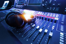 Professional Audio Studio Sound Mixer Console Board Panel With Recording , Faders And Adjusting Knobs,TV Equipment. Blue Tone And Close-up Image With Flare Light Effect.
