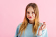 happy pretty teenage girl snapping fingers isolated on pink