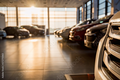 Fotomural New cars at sunlit dealer showroom close view