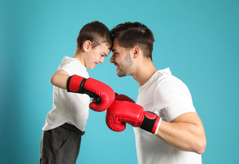 Canvas Print - Dad and his son with boxing gloves on color background