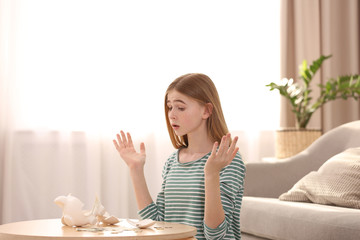 Poster - Sad teen girl with broken piggy bank and money at home