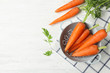 Flat lay composition with carrots in colander on white table. Space for text
