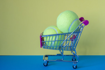 two tennis balls in a food cart cart on a blue surface. sale of sporting goods