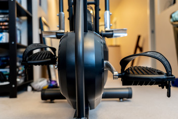 Stationary exercise bike pedals in home gymnasium to keep fit and healthy