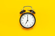 © olgaarkhipenko - Black retro alarm clock on yellow background top view Flat lay copy space. Minimalistic background, concept of time, deadline, time to work, morning