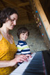 © zhukovvvlad - Children's and women's hands on the piano keys.