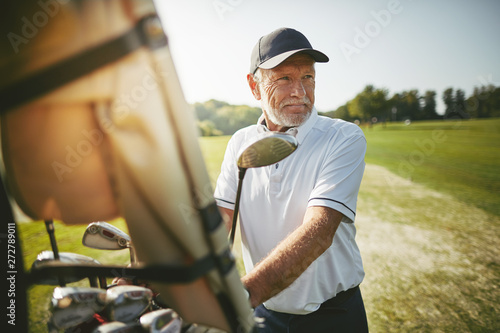 Plakaty Golf  starszy-mezczyzna-przygotowuje-sie-do-gry-w-golfa-w-sloneczny-dzien