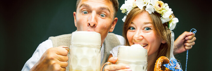 Two friends, men and women, having clinking glasses with beer Oktoberfest