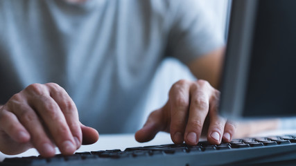 computer programming. coder at work. closeup of male hands using keyboard, typing. copy space.