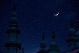 Fototapeta Kosmos - Top of mosque in Eid Ul fitr night with moon and star in sky