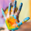 © golubovy - Modern art school. Closeup of hand dirty with blue and yellow paint. Blur background.
