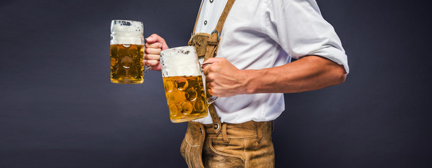 Man in traditional bavarian clothes holding mug of beer