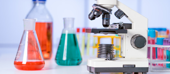 Canvas Print - scientific experiment in school class. Microscope and test tubes on the table