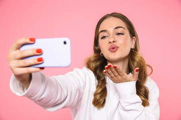 Poster - Lovely woman wearing in casual clothes making selfie on smartphone