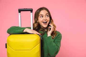 Canvas Print - Cheerful blonde woman wearing in green sweater posing with baggage