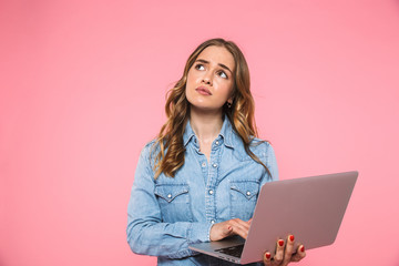 Sticker - Pensive blonde woman wearing in denim shirt using laptop computer