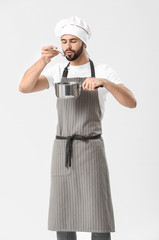 Wall Mural - Handsome male chef with pot on white background