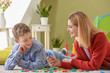© Pixel-Shot - Female psychologist working with boy suffering from autistic disorder