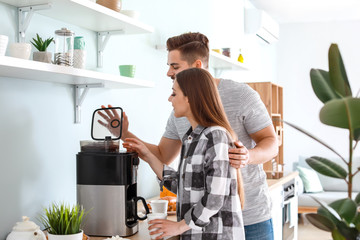 Sticker - Young couple using coffee machine in kitchen