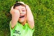 © Mariia Nazarova - cheerful smiling boy lying on the grass in the summer