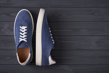 Top View Of Casual Blue Suede Trainers On Grey Wooden Planks