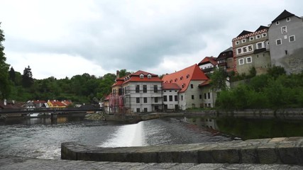 Wall Mural - Cesky Krumlov city captured bridge with flowing Vltava river at riverbank during spring day in slow motion at 120 FPS