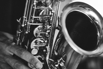 Wall Mural - Black and white closeup picture of hands of a man playing saxophone