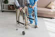 Senior man walking with nurse, and recovering from injury