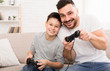 © Prostock-studio - Happy boy enjoying video game with his daddy, playing with joysticks