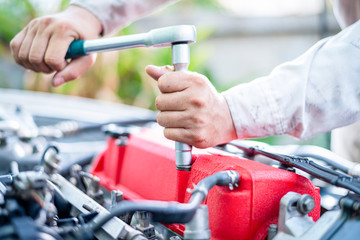 Auto mechanic working on car engine in mechanics garage. Repair service. authentic close-up shot