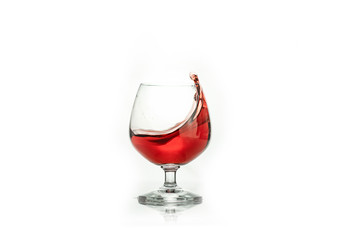 Red wine splashing out of a glass, isolated on white. Concept: alcoholic drinks