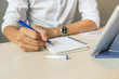 © Quang - Close up of man hand holding pen and writing notes