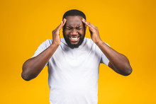 Stressed Young African American Man Feel Pain Having Terrible Strong Headache Concept, Tired Upset Black Guy Massaging Temples Suffering From Migraine Isolated On Yellow Studio Blank Background