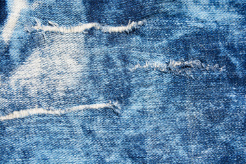 Wall Mural - Denim texture.Blue jeans with threads and holes for the background