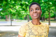 © Mangostar - Portrait of beautiful pensive adult woman. Smiling pensive attractive Black woman standing in park. Weekend in park concept
