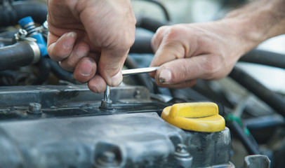 Wall Mural - Wrench in hand. Man working in repair service and fixing car engine