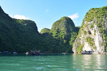 Floating village and rock islands in Halong Bay, Vietnam, Southeast Asia. Travel destination and natural background.