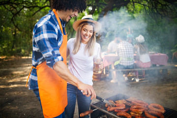 Wall Mural - Friends making barbecue and having lunch in the nature