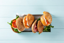 Assorted Sandwiches In Wooden Box On Blue Wooden Background. Healthy Food Concept With Copy Space. Top View.