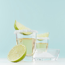 Prepare Tequila Shot Drinks With Salty Edge, Slices Lime In Shot Glass On Pastel Blue Background, Square.
