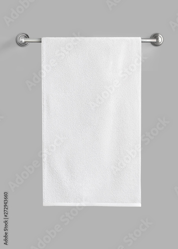 Fotografía White cotton terry towel hanging on the rail isolated