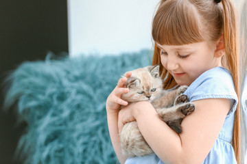 Wall Mural - Girl with cute fluffy kitten at home