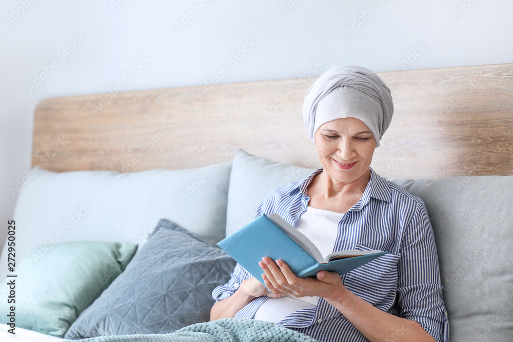 Mature woman after chemotherapy reading book at home