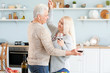 © Pixel-Shot - Portrait of happy mature couple dancing and drinking wine in kitchen